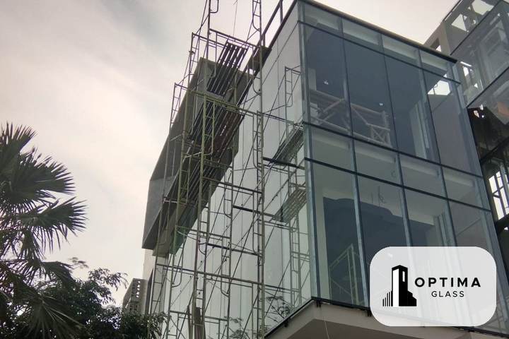Fasad kaca pada volume bangunan dengan rangka aluminium