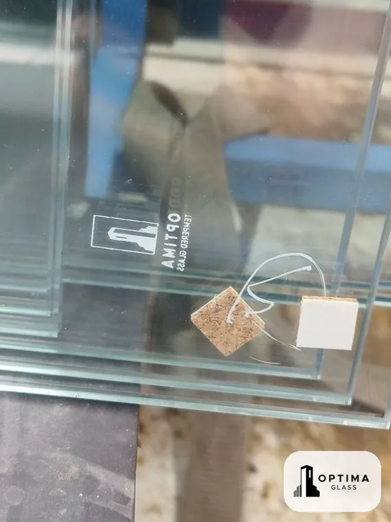 Kaca tempered hasil produksi Optima Glass dengan logo Optima tercetak pada kaca