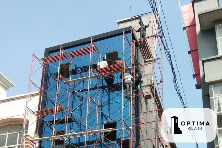 Pemasangan kaca biru tua pada fasad gedung