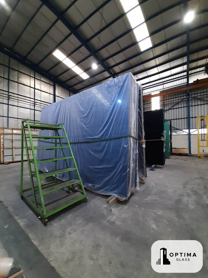 Kaca Stopsol biru berbungkus plastik di gudang Optima Glass