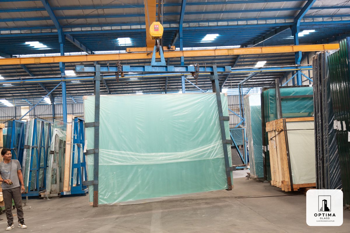 Lembaran kaca ukuran besar diangkat dengan crane di pabrik Optima Glass