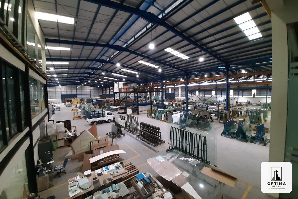 Tampak dalam pabrik kaca Optima Glass di Cikarang dengan rak kaca dan area produksi