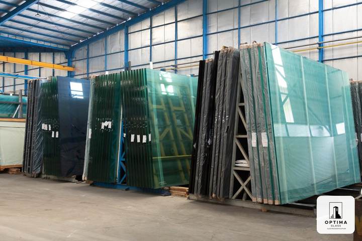 Tumpukan kaca polos clear dan kaca warna di gudang Optima Glass Cikarang sebelum dipotong dan diproses